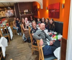 Groups of diners at tables in the orange-walled dining room